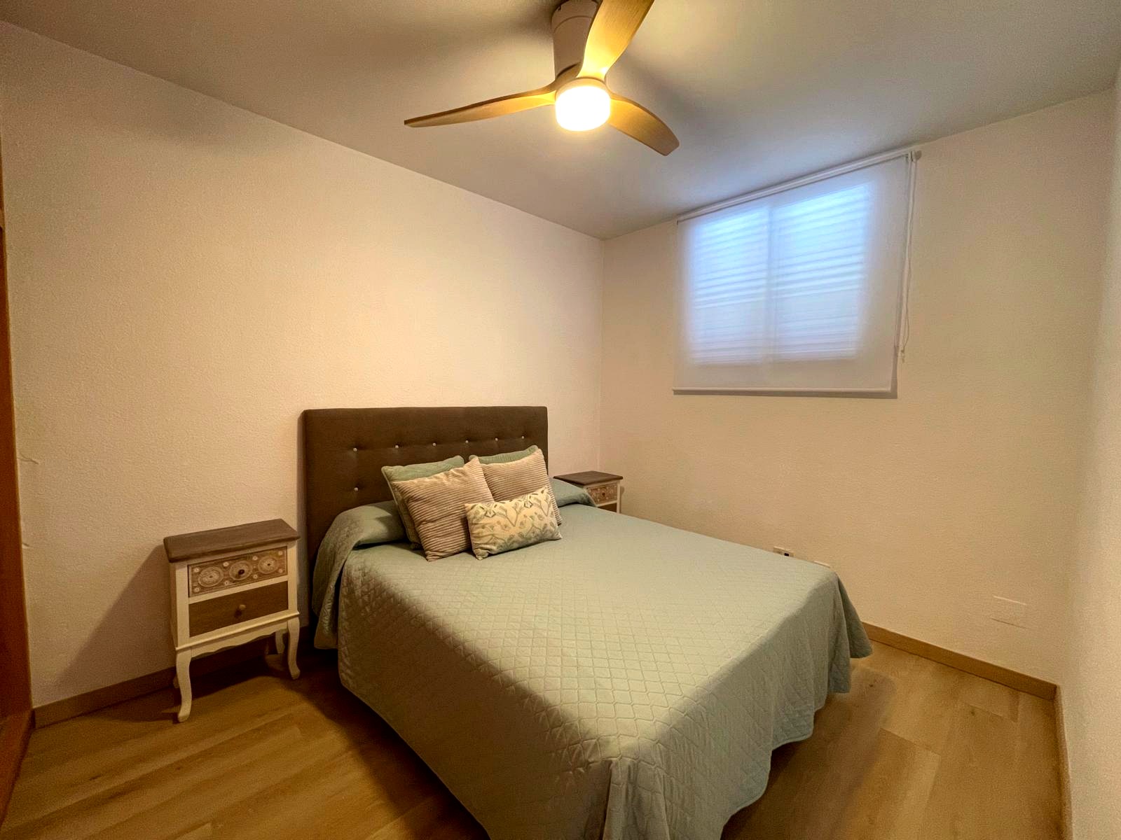 Dormitorio con ventana y ventilador de techo
